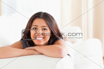 woman lying on sofa with crossed arms looking into camera