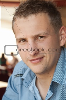 Portrait of a young handsome guy in a cafe