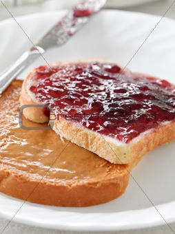 Peanut butter and jelly on pieces of bread.