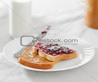 Peanut butter and jelly on pieces of bread.