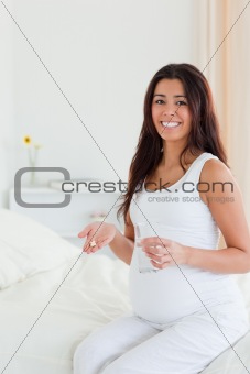 Pretty pregnant woman holding a glass of water and pills 
