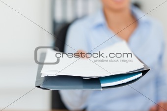 Beautiful woman showing a sheet of paper to the camera