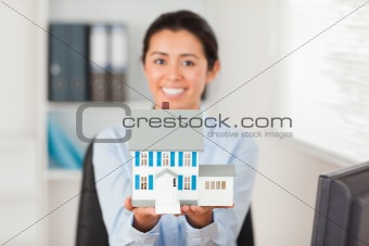 Lovely woman holding a miniature house 