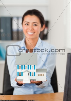 Gorgeous woman holding a miniature house 