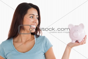 Pretty female holding a piggy bank