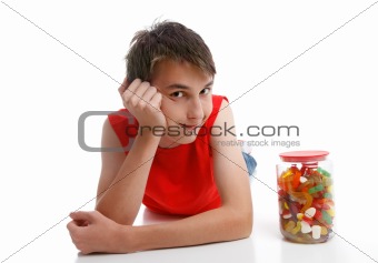 Boy beside an assortment of mixed confectionery