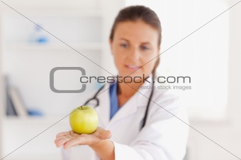 Doctor with stethoscope looking at an apple