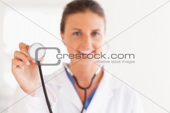gorgeous doctor showing stethoscope to the camera