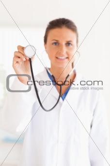 smiling doctor showing stethoscope looking into the camera