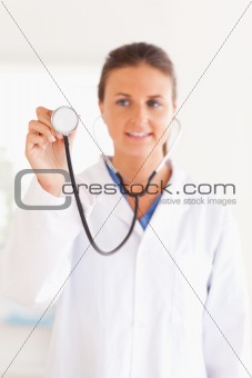smiling doctor presenting a stethoscope looking into the camera