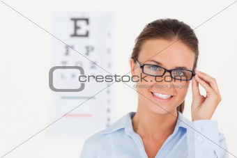 Close up of abrunette eye specialist wearing glasses looking into the camera