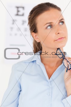 close up of a thinking eye specialist holding glasses