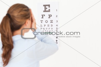 Beautiful brunette woman making an eye test 