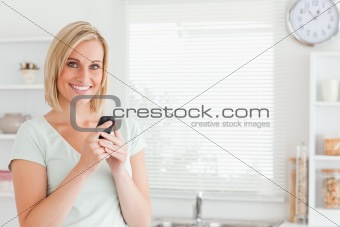 Charming woman with a mobile looking into the camera