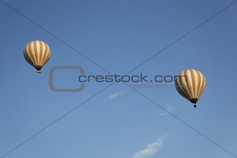 two cream white balloons blue sky