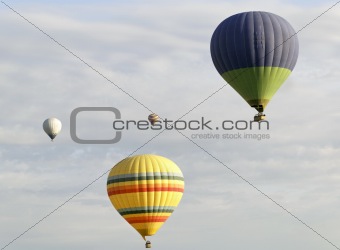 four colorful balloons cloudy sky