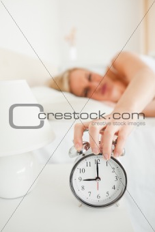 Portrait of a woman switching off her alarm clock