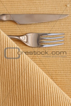 The fork, knife and yellow striped table cloth