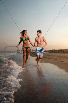 boy and girl running on beach