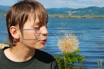 Boy blowing on flower