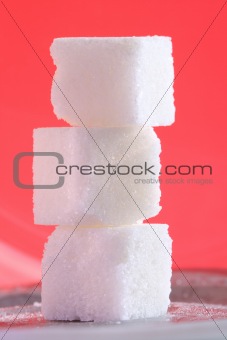Three sugar cubes on the pink background