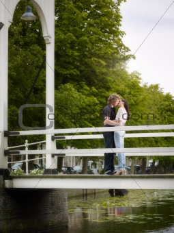 Boyfriend and girlfriend kissing on bridge