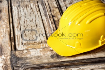 Yellow helmet on burnt wooden log
