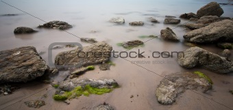 Long exposure of rocks on wet sand