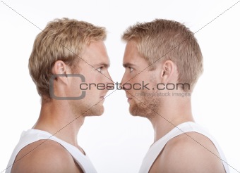 portrait of young twin brothers standing face to face- isolated on white