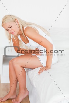 Portrait of a blonde woman having a stomachache