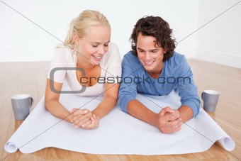 Close up of a couple looking at a plan with cups of coffee