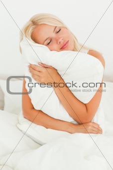 Blonde woman holding a pillow