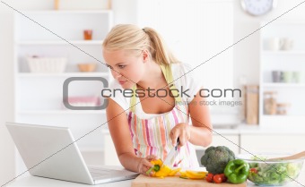 Woman using a laptop to cook