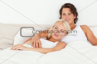 Happy couple lying on a bed