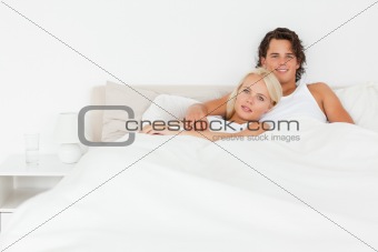 Smiling couple lying on a bed