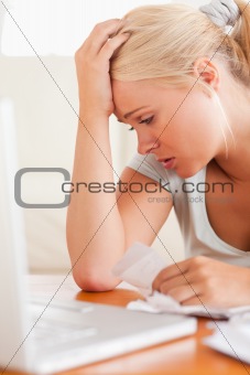 Close up of a Worried blond woman accounting