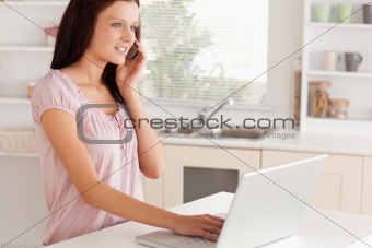 A woman telephoning next to laptop
