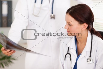 Doctor showing female doctor x-ray