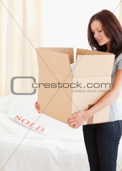 Standing woman holding a cardboard