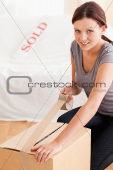 A female preparing a cardboard for transport