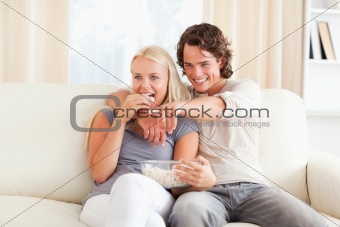 Couple watching TV while eating popcorn