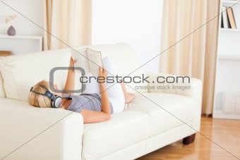 Woman enjoying some music while reading a book