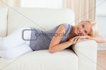 Smiling woman resting on a sofa