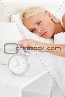 Portrait of a woman awaken by an alarmclock 