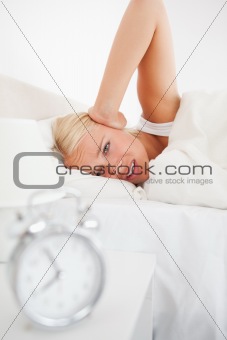 Portrait of an alarmclock waking up a woman