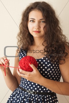 A beautiful young brunette with a ball of thread in their hands