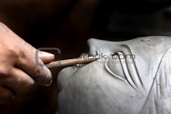 An artisan creating head of clay idol