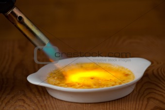 flame caramelizing a creme brulee