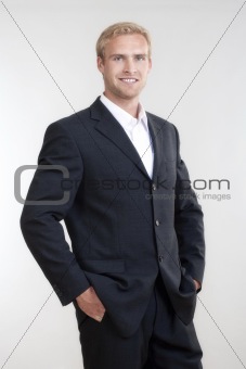 portrait of a young businessman with blond hair in suit smiling - isolated on white