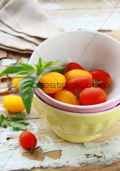 Stack of bowls and fresh tomatoes on a wooden table